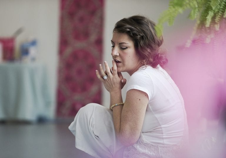 A woman dressed in white sitting on a yoga mat directing a group of women at a mother and daughter retreat in Vancouver focusing on relationships and self care by Vancouver workshop and retreat photographer Angela McConnell